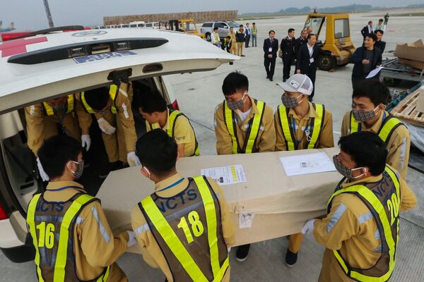 Các nhân viên sân bay Nội Bài, Việt Nam chuyển quan tài với thi thể nạn nhân được phát hiện chết trong xe tải ở Essex, Vương quốc Anh - Sputnik Việt Nam