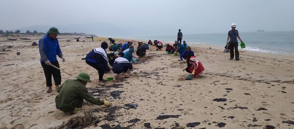 Đoàn viên, thanh niên thu gom cặn dầu trôi dạt vào bờ biển xã Kỳ Lợi, thị xã Kỳ Anh. Đoàn viên, thanh niên thu gom cặn dầu trôi dạt vào bờ biển xã Kỳ Lợi, thị xã Kỳ Anh. - Sputnik Việt Nam
