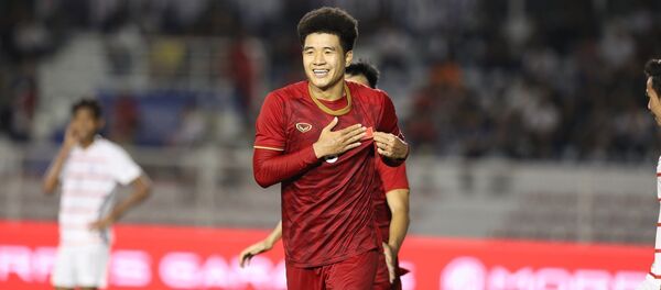 Tiền đạo Hà Đức Chinh (9) đặt tay lên ngực trái, nơi có hình lá quốc kỳ trên áo, sau khi ghi bàn nâng tỷ số trận đấu lên 3 - 0 ở phút 45+2 - Sputnik Việt Nam