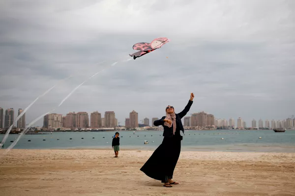 Người phụ nữ Hồi giáo với chiếc diều bay trên bãi biển ở Doha, Qatar Người phụ nữ Hồi giáo với chiếc diều bay trên bãi biển ở Doha, Qatar - Sputnik Việt Nam