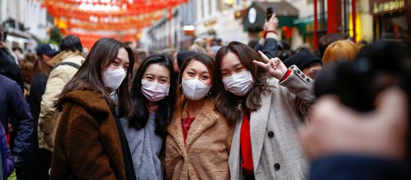 Mọi người đeo khẩu trang trong lễ hội Tết Nguyên đán tại quận phố “China Town” ở London - Sputnik Việt Nam