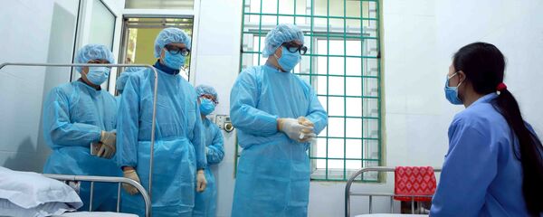 Đội cơ động phản ứng nhanh chống dịch viêm đường hô hấp do Cục trưởng Cục Quản lý Khám chữa bệnh (Bộ Y tế) Lương Ngọc Khuê làm Đội trưởng (thứ 2 từ phải sang) thăm hỏi nữ bệnh nhân dương tính với vi rút Corona tại Trung tâm Y tế huyện Bình Xuyên (Vĩnh Phúc). - Sputnik Việt Nam