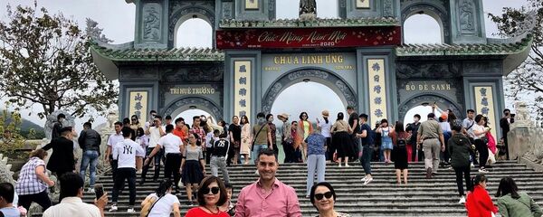 Bà Hoàng Thị Phong Thu chụp ảnh kỷ niệm với du khách Nga trước chùa Linh Ứng Đà Lạt - Sputnik Việt Nam