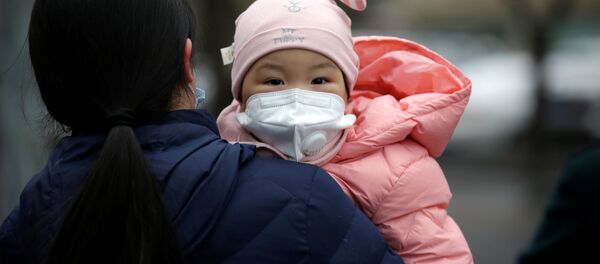 Một phụ nữ có con đeo mặt nạ y tế trên đường phố Bắc Kinh - Sputnik Việt Nam