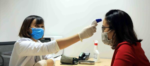 Đo nhiệt độ cho công nhân tại phòng y tế Công ty TNHH sản xuất hàng may mặc Việt Nam (TAL), khu công nghiệp Bá Thiện 2 (huyện Bình Xuyên). - Sputnik Việt Nam