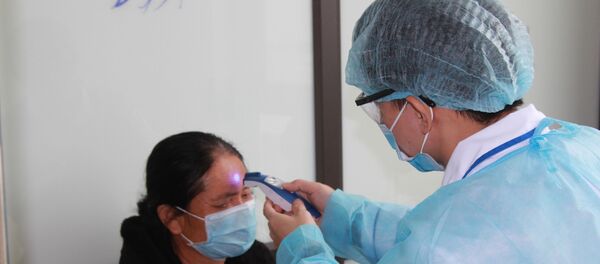 Kiểm tra thân nhiệt định kỳ cho các trường hợp nghi ngờ nhiễm COVID-19. - Sputnik Việt Nam