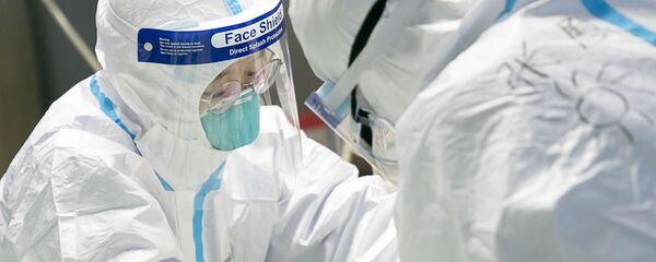 Nhân viên y tế mặc quần áo bảo hộ cho bệnh nhân bị coronavirus tại bệnh viện ở Đại học Vũ Hán Nhân viên y tế mặc quần áo bảo hộ cho bệnh nhân bị coronavirus tại bệnh viện ở Đại học Vũ Hán - Sputnik Việt Nam