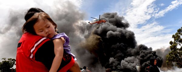 Người dân địa phương nhìn vào một chiếc trực thăng hạ xuống bên cạnh khói lớn từ đám cháy ở Melbourne - Sputnik Việt Nam