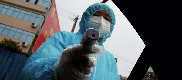 Nhân viên y tế với nhiệt kế tại một trạm kiểm soát ở Trung Quốc Nhân viên y tế với nhiệt kế tại một trạm kiểm soát ở Trung Quốc - Sputnik Việt Nam