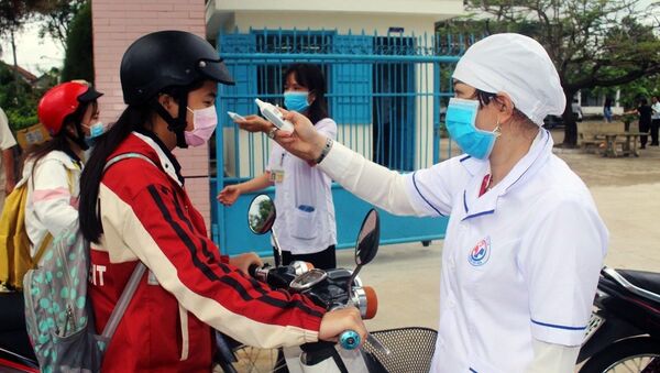 Đo thân nhiệt cho học sinh trường THPT Lê Hồng Phong (huyện Tây Hòa) trước khi vào trường. - Sputnik Việt Nam