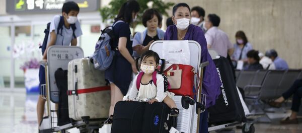 Пассажиры в защитных респираторных масках в аэропорту Гимпо в Сеуле  - Sputnik Việt Nam