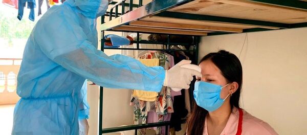 Cán bộ tổ công tác đo thân nhiệt cho người dân trong khu cách ly trường quân sự Sơn Tây. Cán bộ tổ công tác đo thân nhiệt cho người dân trong khu cách ly trường quân sự Sơn Tây. - Sputnik Việt Nam