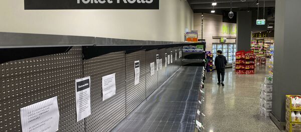 Một khách hàng đi ngang qua kệ không còn giấy vệ sinh trong siêu thị ở Melbourne - Sputnik Việt Nam