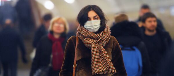 Người phụ nữ trong một mặt nạ y tế trong tàu điện ngầm Moscow. - Sputnik Việt Nam