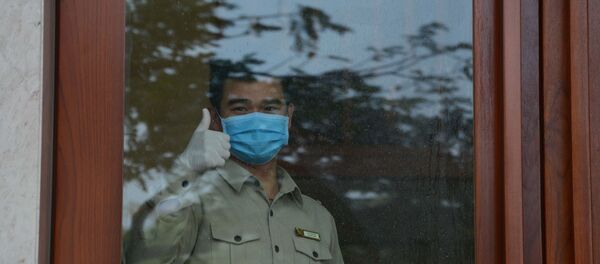 Người bị cách ly tại khách sạn Vanda ra dấu cám ơn lực lượng công an. - Sputnik Việt Nam