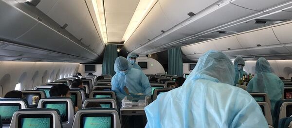 Các tiếp viên mặc trang phục bảo hộ phục vụ hành khách trong suốt 12-13 giờ bay. - Sputnik Việt Nam