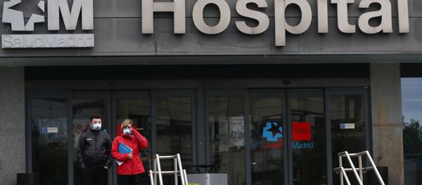 Mọi người đeo khẩu trang đứng gần bệnh viện ở Madrid - Sputnik Việt Nam