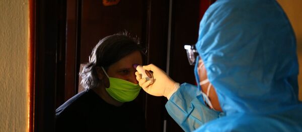 Nhân viên y tế kiểm tra thân nhiệt cho du khách nước ngoài tại khu cách ly tự nguyện ở khách sạn Bưu Điện, phường Bãi Cháy (TP Hạ Long). - Sputnik Việt Nam