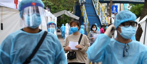 Nhân viên y tế được trang bị đầy đủ quần áo bảo hộ theo đúng quy định phục vụ trạm di động lấy mẫu xét nghiệm. - Sputnik Việt Nam