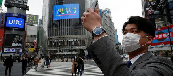 Một người đàn ông đeo khẩu trang chụp ảnh trên điện thoại di động vào buổi trưa tại ngã tư Shibuya ở Tokyo trong đại dịch coronavirus Một người đàn ông đeo khẩu trang chụp ảnh trên điện thoại di động vào buổi trưa tại ngã tư Shibuya ở Tokyo trong đại dịch coronavirus - Sputnik Việt Nam
