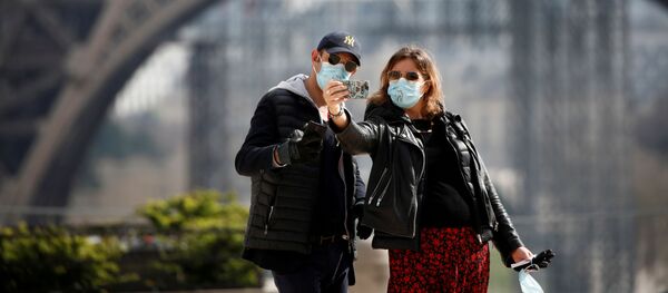 Mọi người chụp ảnh trên phông nền của tháp Eiffel ở Pháp trong thời gian coronavirus - Sputnik Việt Nam