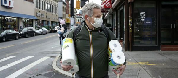 Một người đàn ông bước ra khỏi cửa hàng trong chiếc mặt nạ bảo vệ trong đợt bùng phát COVID-19. New York - Sputnik Việt Nam