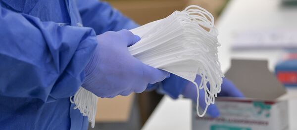 Tay trong găng tay giữ mặt nạ y tế bảo vệ. - Sputnik Việt Nam