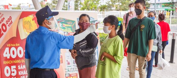 Nhân viên bảo vệ đo nhiệt độ khách hàng tại lối vào một siêu thị ở thành phố nghỉ mát Nha Trang, Việt Nam - Sputnik Việt Nam