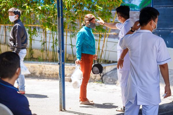 Nhân viên y tế đo nhiệt độ người dân địa phương ở lối vào bệnh viện tại thành phố nghỉ mát Nha Trang, Việt Nam Nhân viên y tế đo nhiệt độ người dân địa phương ở lối vào bệnh viện tại thành phố nghỉ mát Nha Trang, Việt Nam - Sputnik Việt Nam