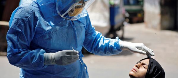 Bác sĩ mặc bộ đồ bảo vệ đang kiểm tra một cô gái bị nhiễm coronavirus ở Ahmedabad, Ấn Độ Bác sĩ mặc bộ đồ bảo vệ đang kiểm tra một cô gái bị nhiễm coronavirus ở Ahmedabad, Ấn Độ - Sputnik Việt Nam