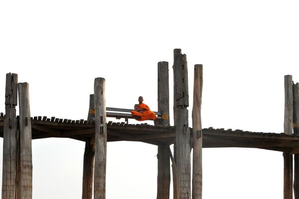 Nhà sư ngồi trên cây cầu gỗ Ubane ở Amarapur, quận Mandalay, Myanmar - Sputnik Việt Nam