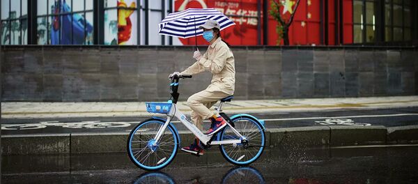 Một người phụ nữ đi xe đạp ở Vũ Hán, tỉnh Hồ Bắc. Ngày 10 tháng 4 năm 2020 Một người phụ nữ đi xe đạp ở Vũ Hán, tỉnh Hồ Bắc. Ngày 10 tháng 4 năm 2020 - Sputnik Việt Nam