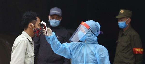 Nhân viên y tế kiểm tra thân nhiệt của người dân thôn Đông Cứu. - Sputnik Việt Nam