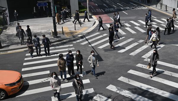 Những người đeo khẩu trang đang băng qua ngã tư dành cho người đi bộ ở Seoul, Hàn Quốc - Sputnik Việt Nam