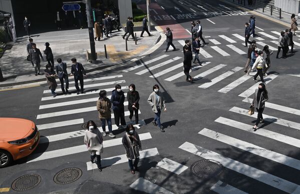 Những người đeo khẩu trang đang băng qua ngã tư dành cho người đi bộ ở Seoul, Hàn Quốc - Sputnik Việt Nam