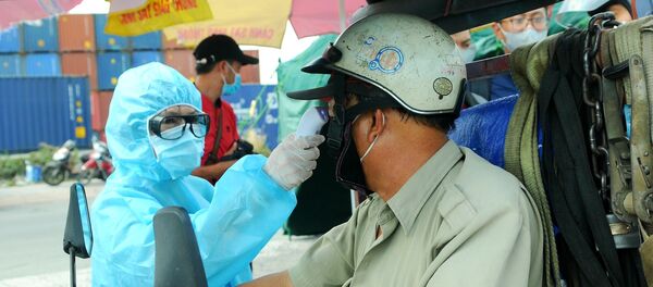 Nhân viên y tế đo thân nhiệt người ra vào thành phố Hồ Chí Minh tại chốt kiểm dịch. - Sputnik Việt Nam