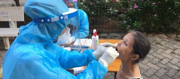 Nhân viên y tế lấy mẫu xét nghiệm tại khu dân cư. - Sputnik Việt Nam