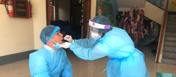 Lấy mẫu dịch họng cho chuyên gia y tế đến từ Bệnh viện Đa khoa tỉnh Hà Giang lên hỗ trợ điều trị cho bệnh nhân 268. Lấy mẫu dịch họng cho chuyên gia y tế đến từ Bệnh viện Đa khoa tỉnh Hà Giang lên hỗ trợ điều trị cho bệnh nhân 268. - Sputnik Việt Nam