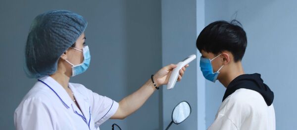 Lực lượng y tế đo thân nhiệt người dân khi vào bệnh viện. - Sputnik Việt Nam