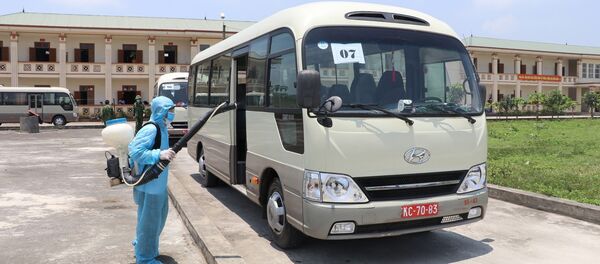 Thực hiện khử khuẩn xe chở các công dân sau khi hoàn thành nhiệm vụ.  - Sputnik Việt Nam