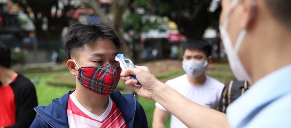 Kiểm tra thân nhiệt cho khách vào thăm quan Di tích lịch sử Văn Miếu - Quốc Tử Giám sáng 14/5. - Sputnik Việt Nam