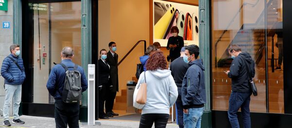 Nhân viên và khách hàng đeo khẩu trang y tế tại cửa hàng thương hiệu Apple ở Zurich, Thụy Sĩ - Sputnik Việt Nam