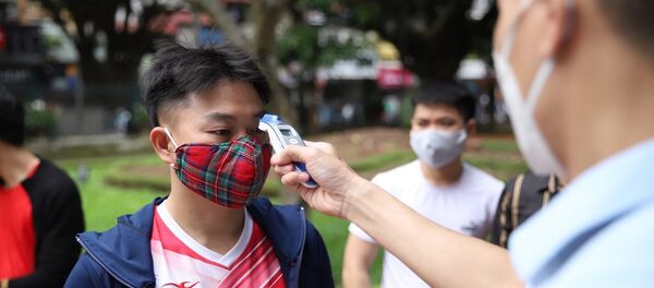 Kiểm tra thân nhiệt cho khách vào thăm quan Di tích lịch sử Văn Miếu - Quốc Tử Giám sáng 14/5. - Sputnik Việt Nam