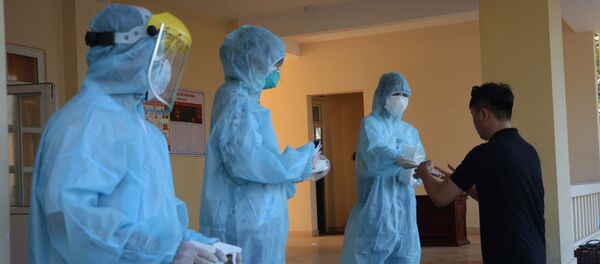 Nhân viên y tế khử trùng tay, phát khẩu trang y tế cho công dân trở về từ Hàn Quốc. - Sputnik Việt Nam