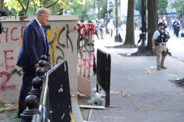 Tổng thống Mỹ Donald Trump đi ngang qua một tòa nhà được vẽ nguệch ngoạc graffiti của những người biểu tình ở Công viên Lafayette, đối diện Nhà Trắng - Sputnik Việt Nam