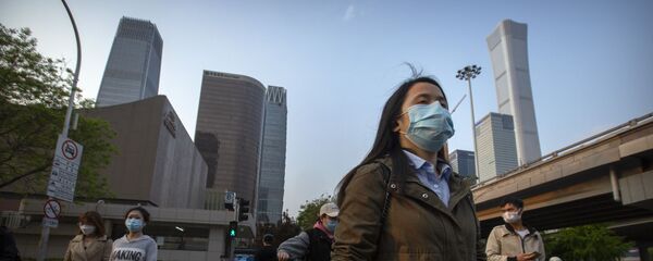 Người qua đường đeo khẩu trang trên nền các tòa nhà chọc trời ở khu thương mại Bắc Kinh, Trung Quốc. Người qua đường đeo khẩu trang trên nền các tòa nhà chọc trời ở khu thương mại Bắc Kinh, Trung Quốc. - Sputnik Việt Nam