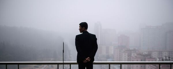 Một người đàn ông trên ban công một ngôi nhà ở Bình Nhưỡng vào một ngày sương mù - Sputnik Việt Nam