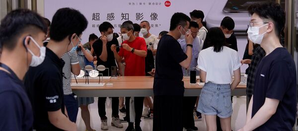 Khách tham quan đeo khẩutrang bảo vệ tại cửa hàng Huawei Khách tham quan đeo khẩutrang bảo vệ tại cửa hàng Huawei - Sputnik Việt Nam